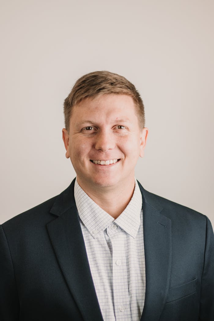 Professional headshot of a smiling man in a suit, ideal for business branding and profiles.